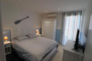 1 dormitorio con 1 cama y escritorio con TV en résidence Monte leone, en Bonifacio