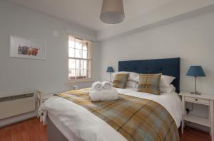 a bedroom with a large bed with a stuffed animal on it at The Wee Highland Coo in Edinburgh