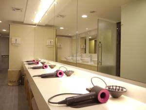 a bathroom with a long counter with a large mirror at Eastin Taipei Hotel in Taipei