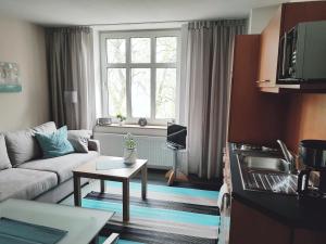 a living room with a couch and a table at Gemütliche Maisonette am Kurpark in Bad Rothenfelde