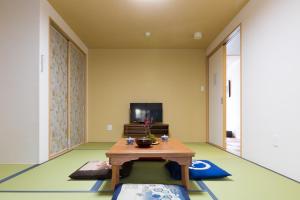 a living room with a table and a tv at Kyonomachi Hakuho in Kyoto