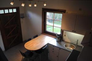 a kitchen with a wooden table and a sink and a window at 't Huizeke in Asse