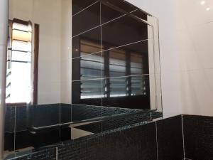 a mirror on the wall of a bathroom at Residence Maison Müge in Kilifi