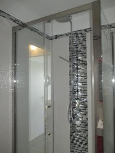 La salle de bains est pourvue d'une douche avec une porte en verre. dans l'établissement Studio vue mer à Saint Valéry en caux, à Saint-Valery-en-Caux