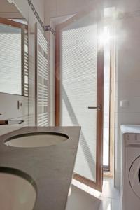 a bathroom with a sink and a washing machine at Vistay apartments in Luxembourg