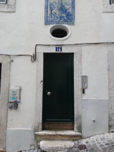 a green door on the side of a building at Bica Mini Hostel in Lisbon
