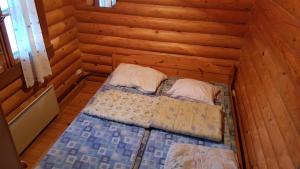 a small room with a bed in a log cabin at Kalajärven Lomakylä in Peräseinäjoki