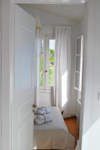 ein weißes Schlafzimmer mit einem Bett und einem Fenster in der Unterkunft Villa "Pietra e Mare" in Nafpaktos