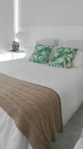 a white bed with a blanket on top of it at Apartamento Calero in Puerto Calero