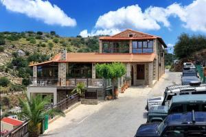 a house with cars parked in front of it at Archontiko Manias in Axós