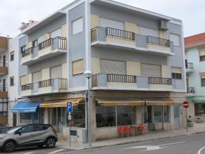 um prédio de apartamentos com um carro estacionado em frente em Serena Beach 2 na Nazaré