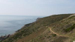 een onverharde weg op een heuvel naast de oceaan bij Gîtes La Vicomterie in Ver