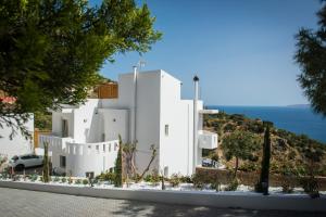 een wit huis met uitzicht op de oceaan bij Villa Artemis, Wine Dark Sea Villas in Rodhiá