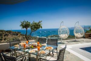 Rodhiá的住宿－Villa Artemis, Wine Dark Sea Villas，一张桌子,上面有食物,享有海景