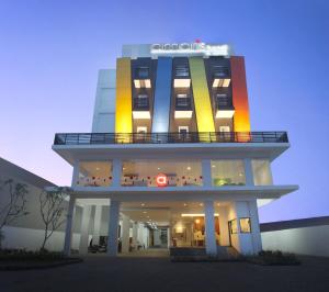 un grand bâtiment avec une façade colorée la nuit dans l'établissement Amaris Hotel Malang, à Malang