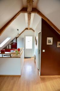 una cocina en el ático con armarios blancos y vigas de madera en Le gite d'Or, en Vouvray