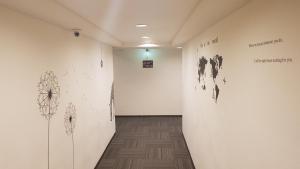 a hallway with black and white drawings on the wall at Jung Shin Hotel in Zhongli