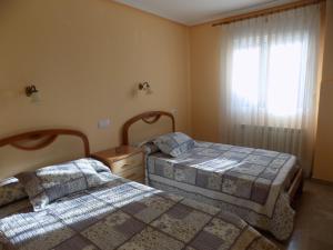 1 dormitorio con 2 camas y ventana en Apartamentos Las Llábanas en Oviñana