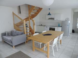 a kitchen and dining room with a table and a staircase at Maison "Ouessant" Pays des Abers in Plouguerneau