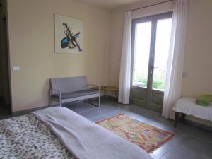 a bedroom with a bed and a window and a chair at Casa Vacanze San Stefanetto in Treiso