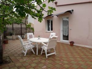 una mesa blanca y sillas en un patio en Casa Vacanza Campoli, en Ruffano