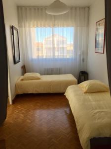 two beds in a room with a window at Bel appart vue mer in Valras-Plage