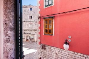 een uitzicht vanuit een raam van een rood gebouw bij Apartments Palace Rialto in Šibenik