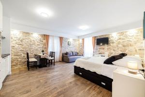 een slaapkamer met een bed en een stenen muur bij Apartments Palace Rialto in Šibenik