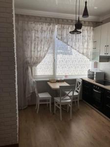 a kitchen with a table and chairs and a window at Morskaya zhemchuzhina na Marselskoy in Kryzhanivka