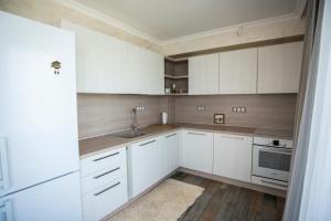 a kitchen with white cabinets and a sink at Villa Lili in Sozopol +35 photos