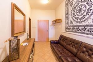 a living room with a brown leather couch and a mirror at Apartment Sirius D in center of CB. in České Budějovice