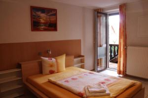 a small bedroom with a bed with a balcony at Landhaus Burs in Löningen