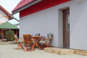 a patio with two chairs and a table next to a door at Petúnia-dom s dvoma spálňami in Bešeňová