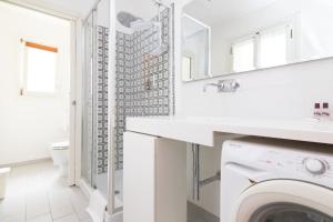 La salle de bains blanche est pourvue d'un lave-linge et d'un lavabo. dans l'établissement Bella Vita Charming House, à Venise