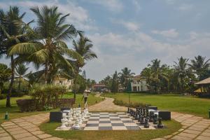 a patio area with tables, chairs and umbrellas at Royal Orchid Beach Resort & Spa, Utorda Beach Goa in Utorda