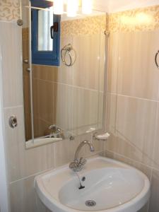 La salle de bains est pourvue d'un lavabo et d'un miroir. dans l'établissement Chris Apartments, à Marathokampos