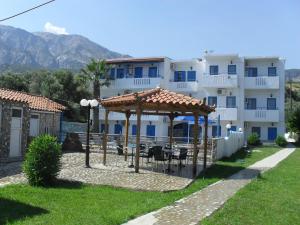 a building with a gazebo in front of it at Chris Apartments in Marathokampos