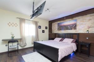 1 dormitorio con 1 cama grande y pared de ladrillo en Villa Blanca Tenerife - Complete House - Terrace and BBQ, 5 minutes from the beach and airport, en San Isidro