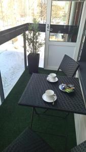 City Apartments With Balcony في روفانييمي: طاولة سوداء وكراسي عليها طبق من الطعام
