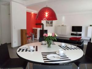 a dining room with a table and a red lamp at dat witte hus 1 in Büsum