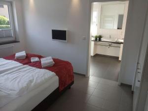 Un dormitorio con una cama y un baño con lavabo. en dat witte hus 1, en Büsum