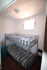 two bunk beds in a room with a window at Appartamenti Villa Monticelli in Marina di Campo