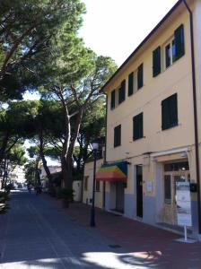 um edifício com um dossel de arco-íris ao lado de uma rua em Appartamenti Villa Monticelli em Marina di Campo