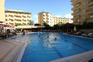 personas nadando en una piscina en un hotel en Kleopatra Royal Palm Hotel, en Alanya