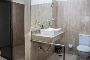 a bathroom with a sink and a toilet at Hotel Paradizzo in Foz do Iguaçu