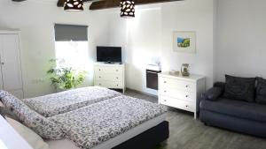 1 dormitorio con 1 cama, 1 silla y TV en Ferienwohnung in Seewalchen, en Seewalchen