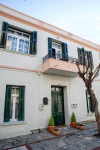 a white building with a green door and windows at The Old Salt in Kavala