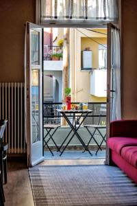 a room with a door open to a balcony with a table at The Old Salt in Kavala