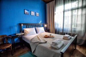 a blue bedroom with a bed with a tray of food on it at The Old Salt in Kavala +26 photos