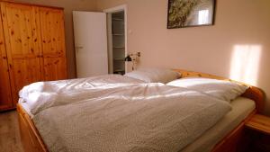 Un dormitorio con una cama con sábanas blancas. en house46-1, en Hohen Neuendorf